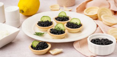 Hafif arka planda siyah havyarlı lezzetli tart tabağı.