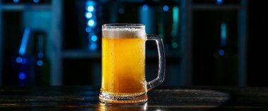 Bardaki masada bir bardak taze bira.