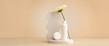 Alçı tezgahları, çiçek, kavanoz ve bej arka planda kozmetik ürünlerle dolu şişe