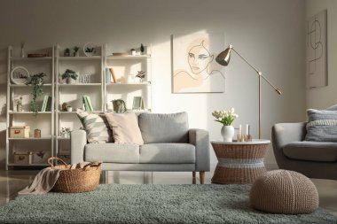 Oturma odasının içinde kanepe, raf üniteleri ve yapay bitkiler var.