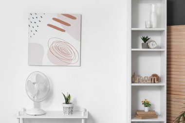 Elektrik vantilatörü, ışık odasının iç tarafındaki rafta.