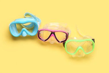 Sarı arka planda farklı yüzme maskeleri