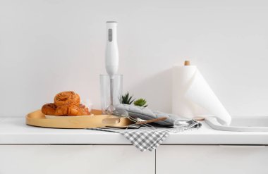 Fırın için taze çöreklerle mutfak masası ve çatal bıçak takımı.