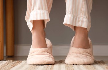 Evde yumuşak terlikli genç bir kadın, yakın plan.