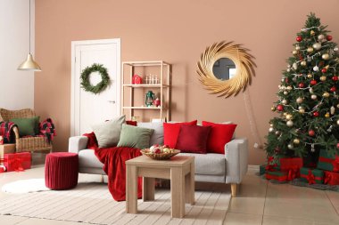 Oturma odasının içinde kanepe, masa ve Noel ağacı var.