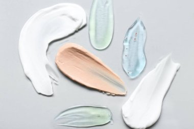 Beyaz arka planda fırça, jel ve makyaj temeli olan kozmetik kremi örnekleri