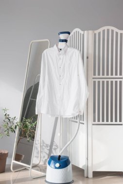 Buharlı ve beyaz gömlekli bir oda.