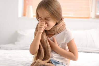 Yatak odasında öksüren küçük hasta kız.