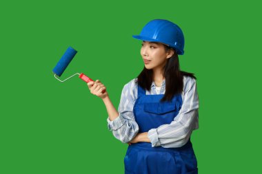 Yeşil arka planda yuvarlanan Asyalı kadın ressam