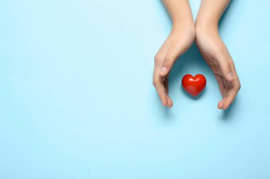 Mavi arka planda kırmızı kalpli kadın elleri