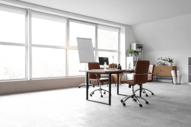 Penceresi, masası ve koltukları olan ışık konferans salonu.