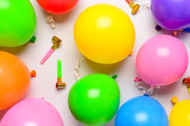 Beyaz arka planda balonlar, konfetiler ve gürültü çıkaranlar