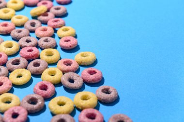 Mavi arkaplanda renkli tatlı mısır gevreği halkaları