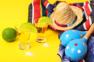 Sarı arka planda tekila, limon ve marakas.