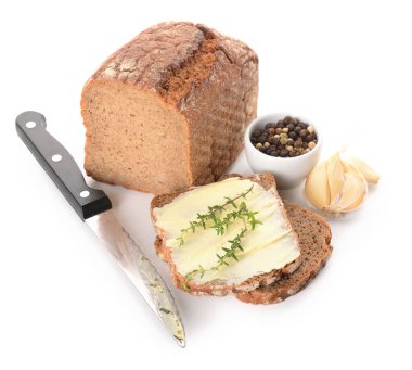 Taze tereyağlı ekmek dilimleri, sarımsak ve beyaz arka planda bir kase biber.