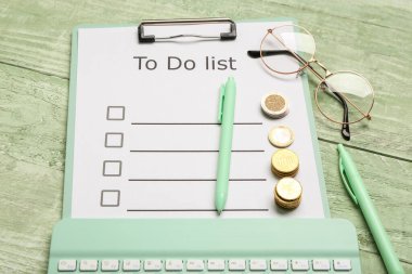 Listesi yapılacak pano, yeşil ahşap arka planda gözlük ve bozuk paralar. Zaman yönetimi kavramı