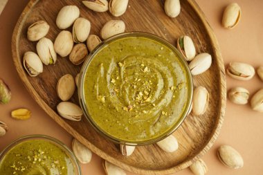 Ahşap tepsi ve fındık ezmeli kâseler kahverengi arka planda.