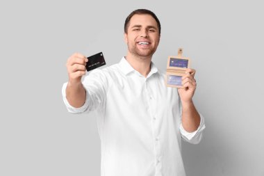 Beyaz arka planda cüzdanı ve kredi kartı olan genç bir adam.