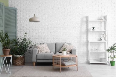 Rahat kanepesi, lambası ve raf ünitesi olan şık bir oturma odası.