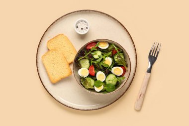 Kaynamış bıldırcın yumurtalı bir kase lezzetli salata, deniz tuzu ve renkli tost.