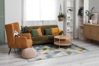 Oturma odasında rahat bir kanepe, koltuk, puf ve kahve masası.