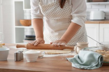 Kadın mutfakta geleneksel tarçınlı rulo hazırlıyor.
