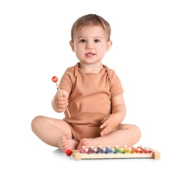 Beyaz arka planda ksilofonla oynayan şirin bir bebek.