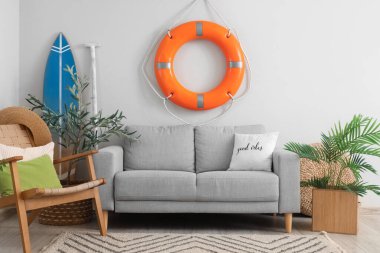 Oturma odasında rahat bir kanepe, koltuk ve can simidi.