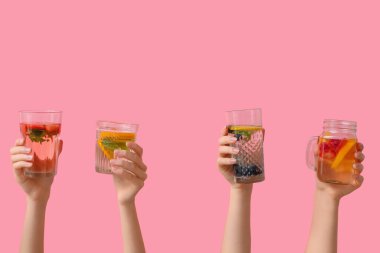 Pembe arka planda erimiş su olan birçok el