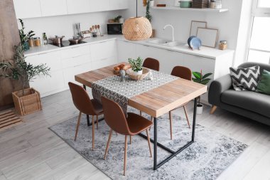 Heykeller, ev bitkisi ve hasır kase yemek odasındaki masada.