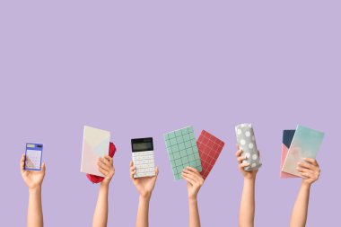 Leylak arka planında farklı kırtasiye malzemesi olan kadın elleri