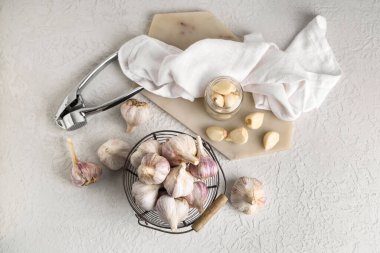 Taze sarımsaklı sepet ve beyaz arka planda karanfil.