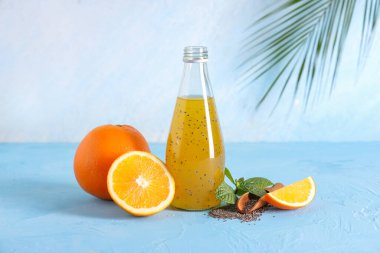 Mavi grunge arka planında Chia tohumu, portakal ve naneli bir şişe limonata.