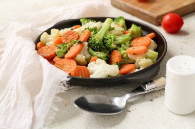 Beyaz grunge arka planda lezzetli kızarmış sebzeli tava, yakın plan.