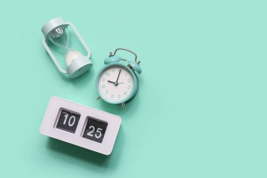 Turkuaz arka planda çalar saatli kum saati. Evrim kavramı