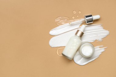 Kavanoz, kozmetik ürünler ve bej arka planda örnekler.