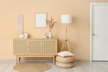 Odanın içinde ahşap tuvalet, boş çerçeve ve lamba var.