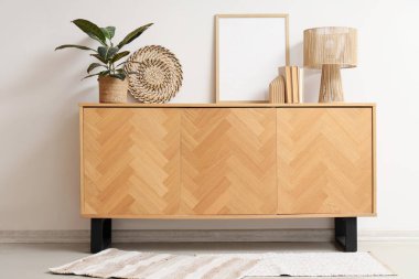 Kitaplı boş çerçeve, lamba ve bitki odasındaki ışık duvarının yanındaki ahşap klozette.