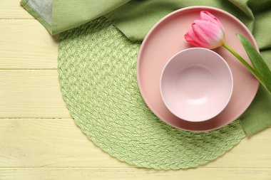 Sarı ahşap arka planda pembe lale çiçekli güzel bir masa.