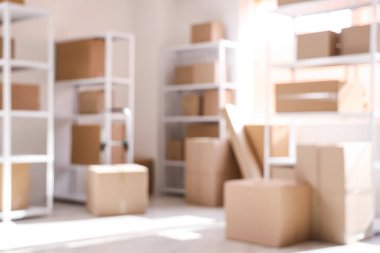Raflarda karton kutular olan hafif deponun bulanık görüntüsü