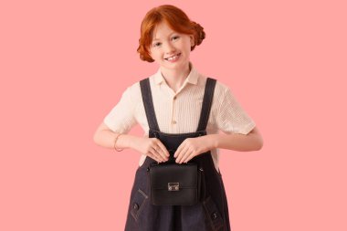 Pembe arka planda şık giyinmiş tatlı kızıl kız.