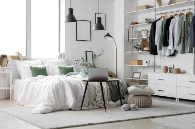 Işıl ışıl yatak odası, rahat yatağı, laptopu komodinin yanında ve şık gardırobu var.