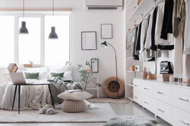 Işıl ışıl yatak odası, rahat yatağı, laptopu komodinin yanında ve şık gardırobu var.