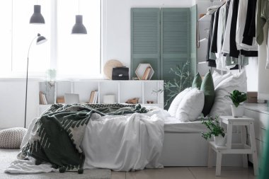 Konforlu yatağı ve şık gardırobu olan hafif yatak odasının içinde.