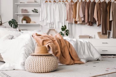 Konforlu yatağı, çiçekleri ve şık gardırobu olan aydınlık yatak odası.