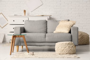 Depremden sonra gri kanepe ve kahve masası olan dağınık bir oturma odası.