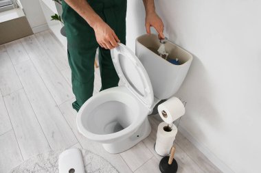 Erkek tesisatçı tuvaleti tamir ediyor, yakın plan.