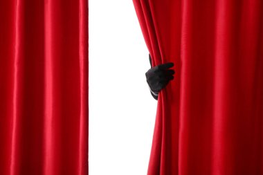 Beyaz arka planda izole edilmiş kırmızı kadife perdeleri açan kadın el.