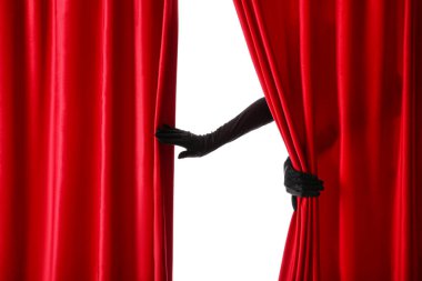 Beyaz arka planda kırmızı kadife perdeleri açan kadın elleri