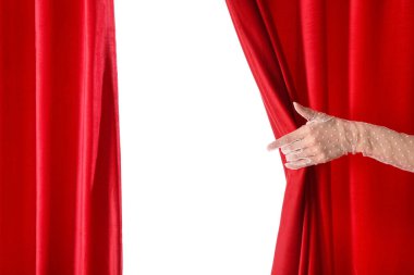 Beyaz arka planda izole edilmiş kırmızı kadife perdeleri açan kadın el.